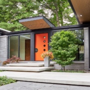 Covered entry with floor to ceiling window and stone siding.