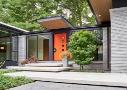 Covered entry with floor to ceiling window and stone siding.