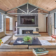 Modern family room with brick fireplace, stone wall and wood ceiling.