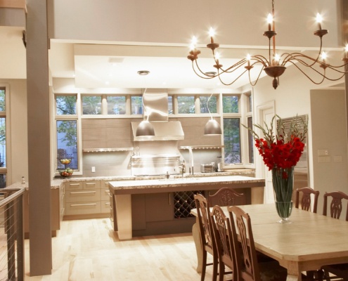 Open concept dining room with steel columns, wood dining table and high ceilings.